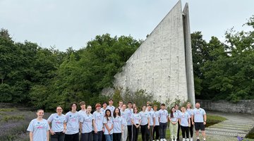 Die Teilnehmer der Internationalen Jugendbegegnung vor der Gedenkhalle des Münchner Waldfriedhofs.